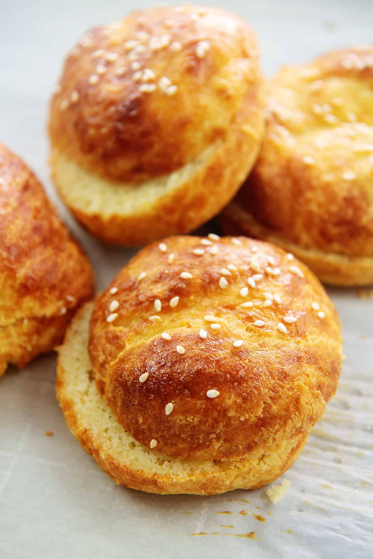 keto hamburger buns piled on parchment paper.