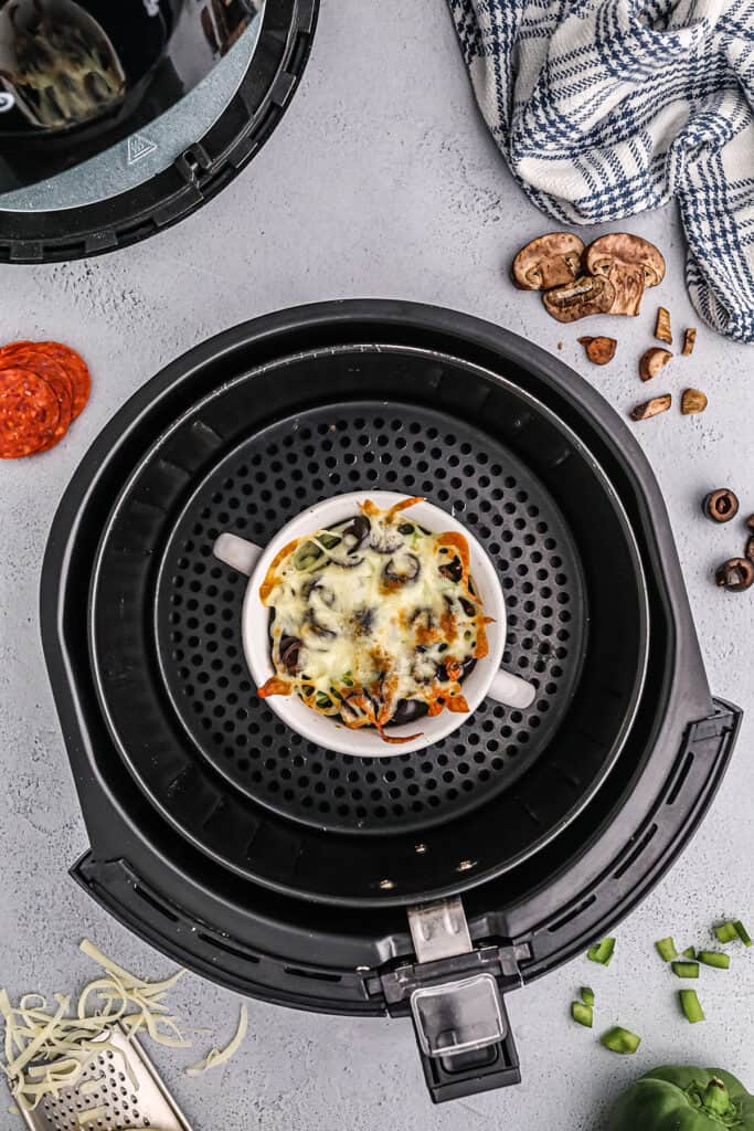 crustless pizza in air fryer basket.