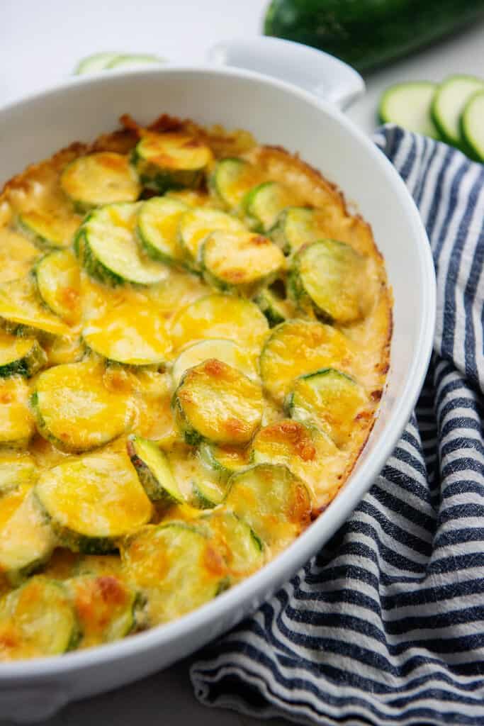 cheesy zucchini gratin in white baking dish.