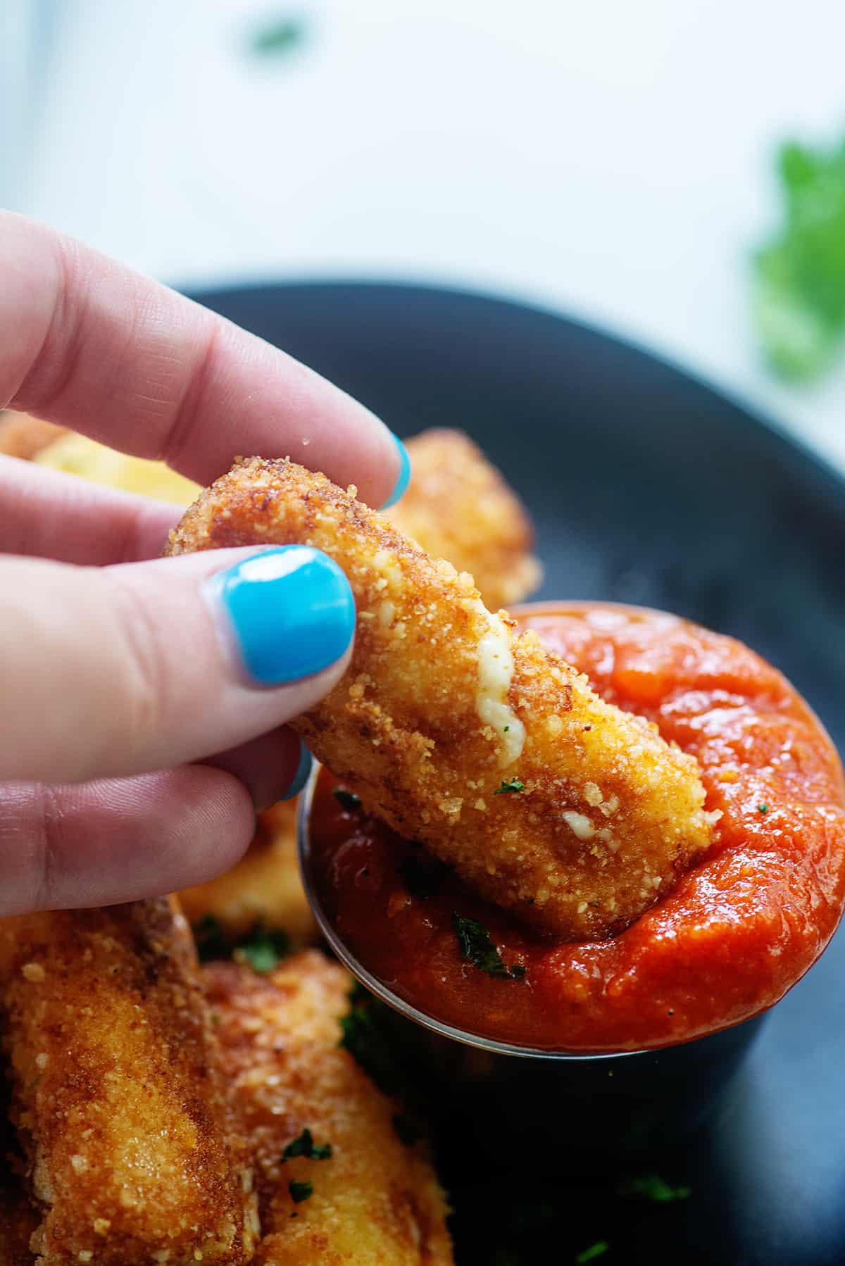 mozzarella stick being dunked in marinara.