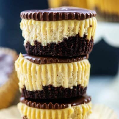 stack of mini peanut butter cheesecakes topped with chocolate.