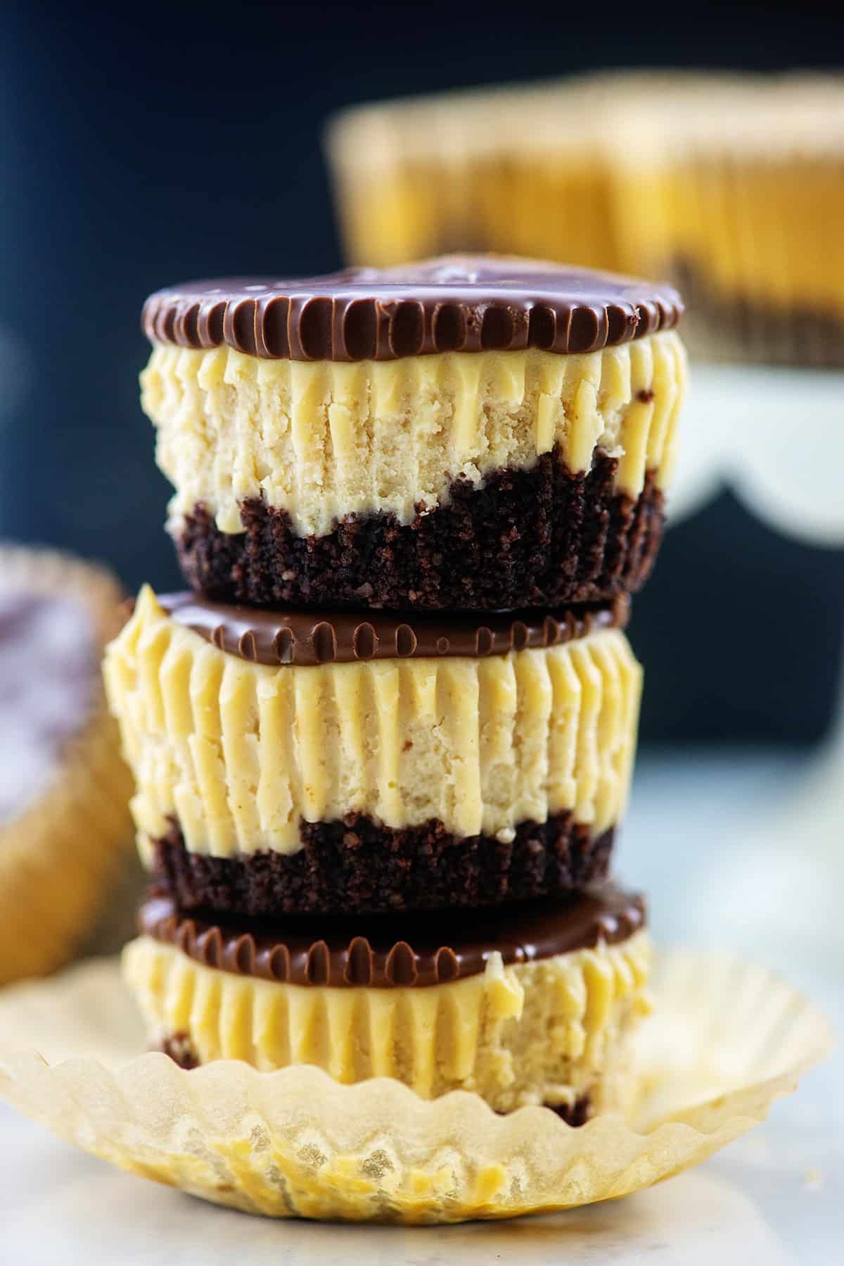 stack of mini peanut butter cheesecakes topped with chocolate.