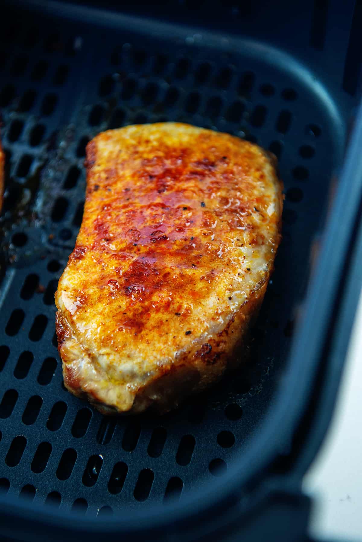 boneless pork chop in air fryer basket.