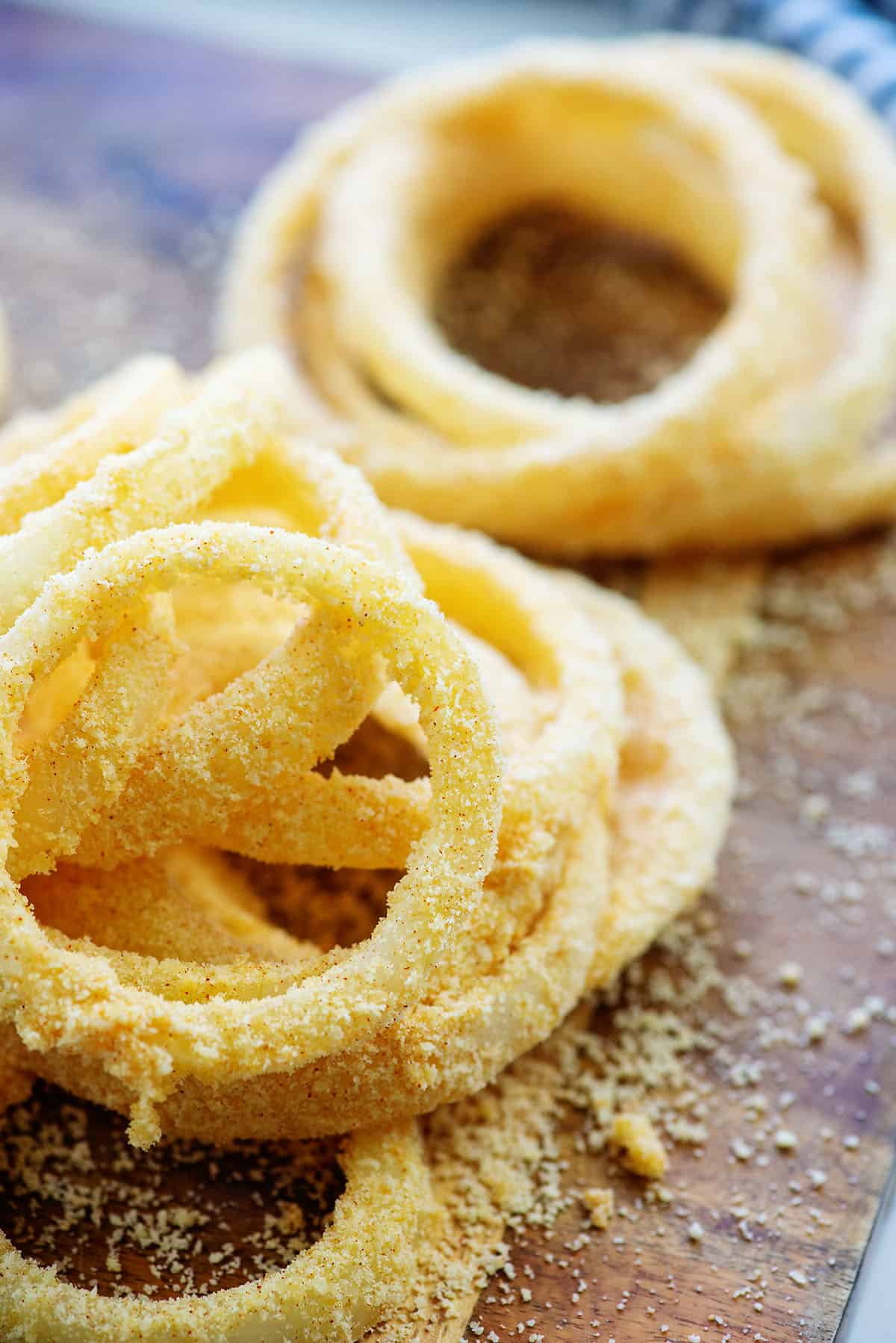 breaded onion rings on cutting board.