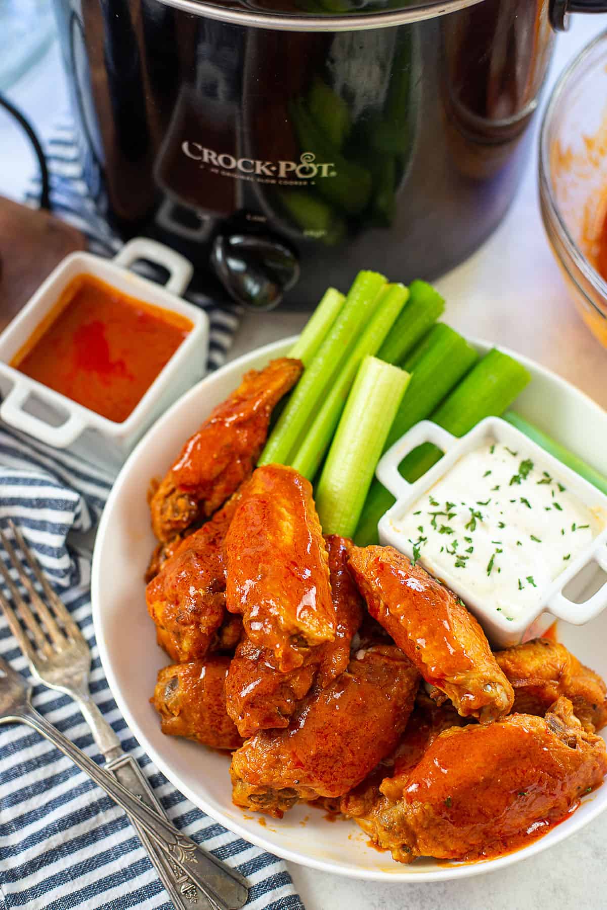 crockpot buffalo chicken wings piled in bowl.