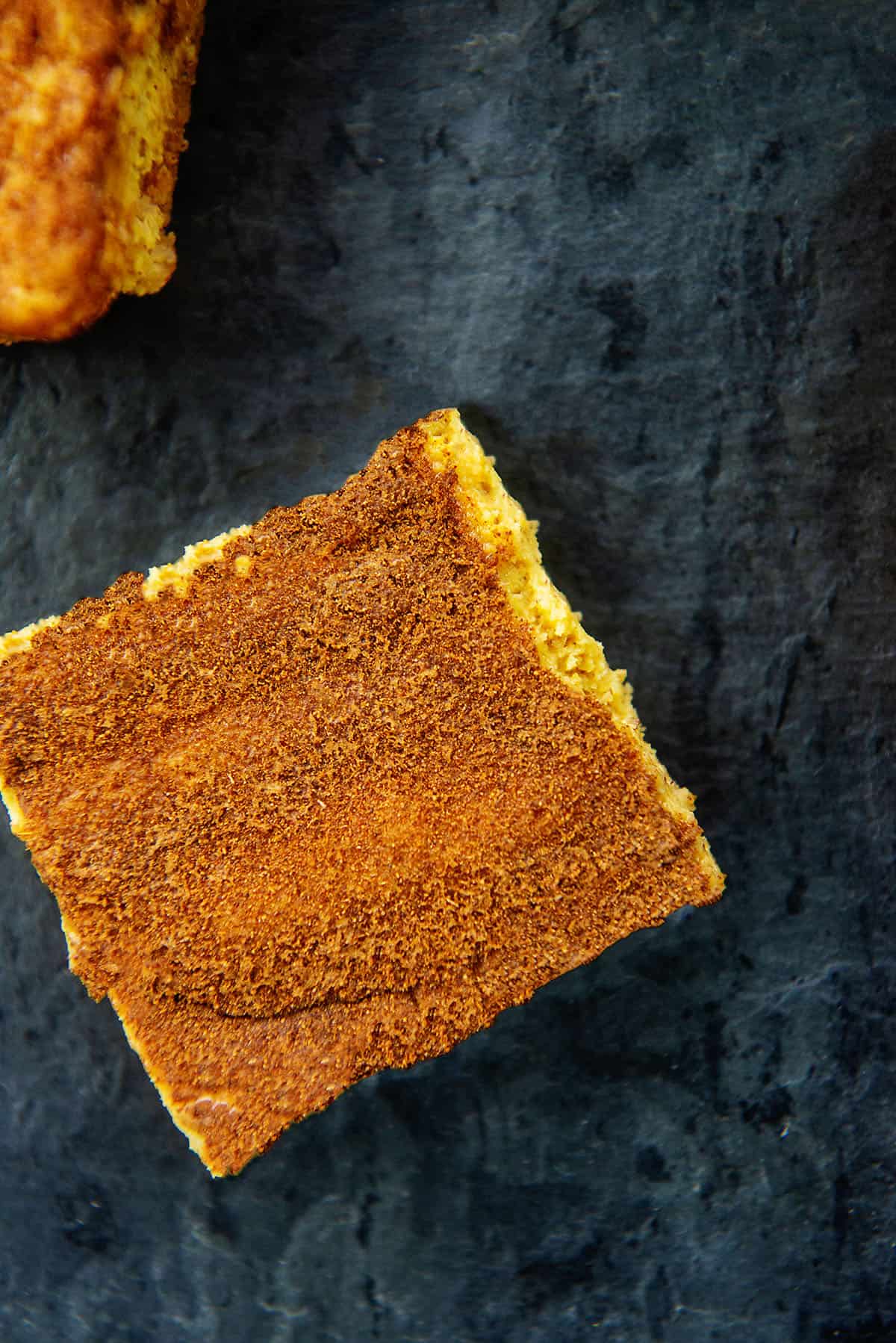 keto pumpkin cheesecake bar on slate surface.