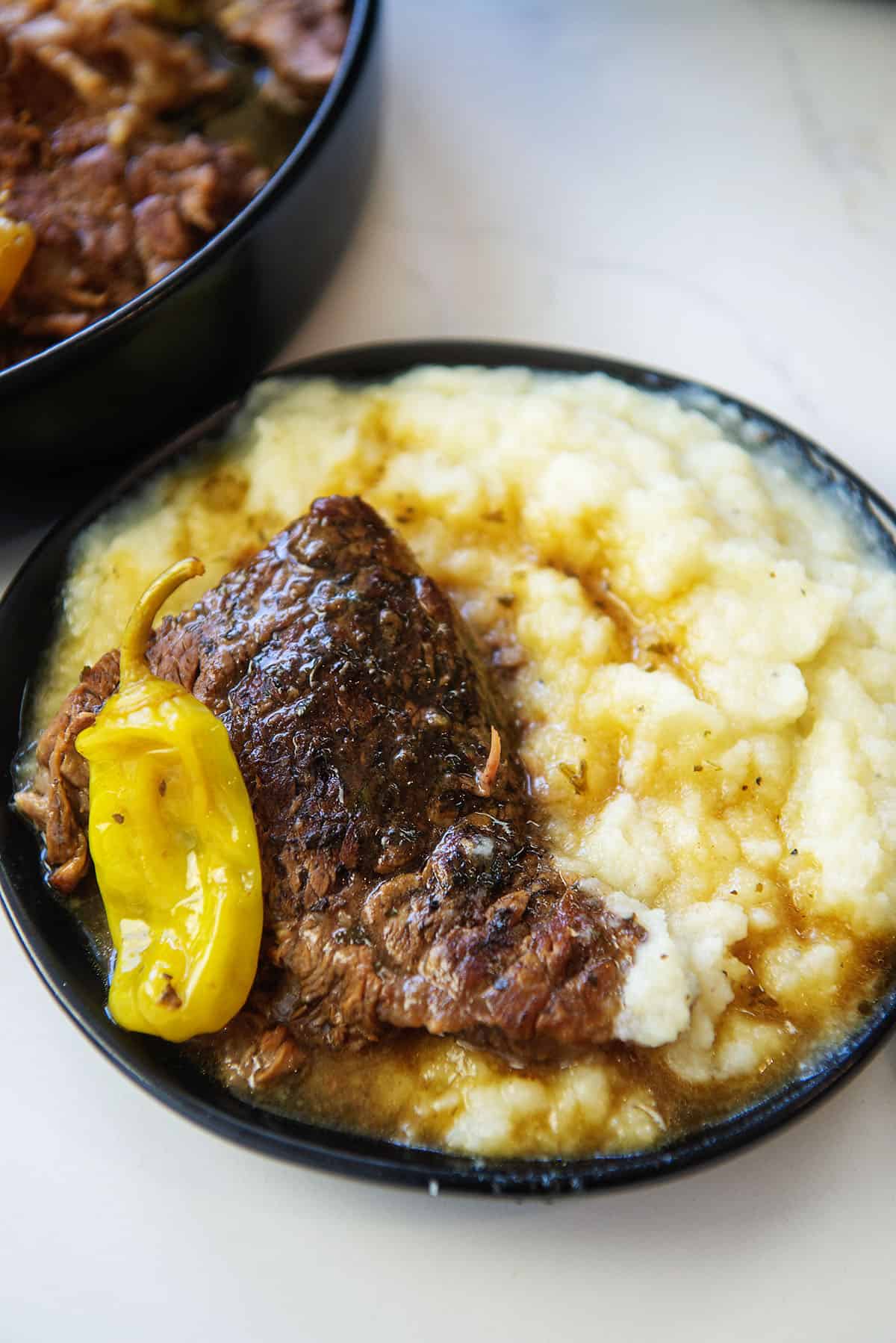 low carb Mississippi pot roast on black plate with cauliflower mash.