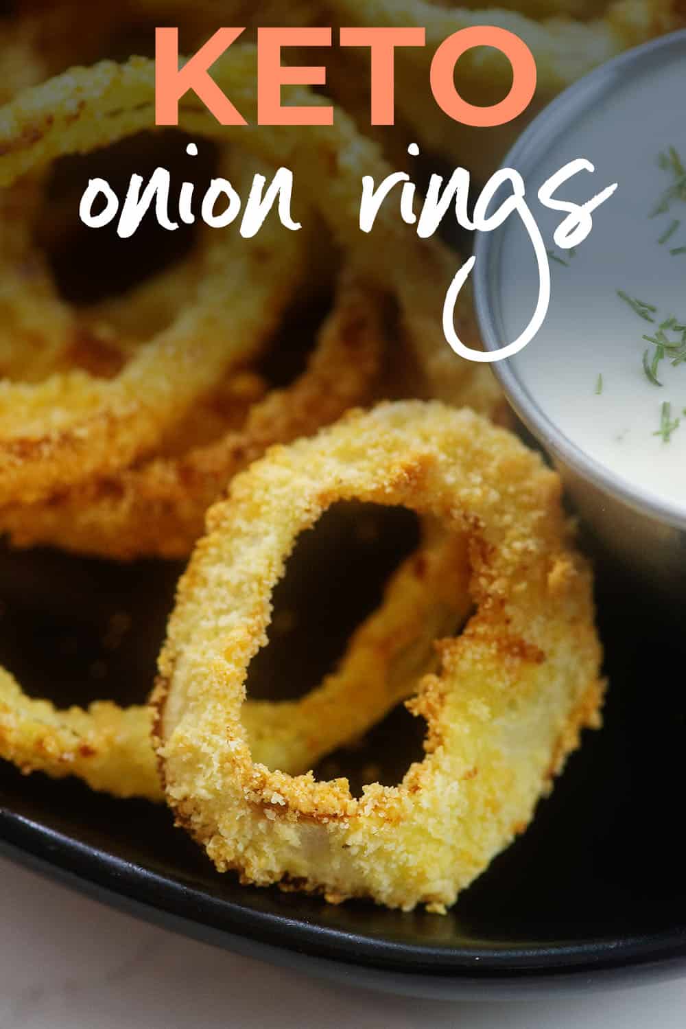 keto onion rings on black plate with text for PInterest.