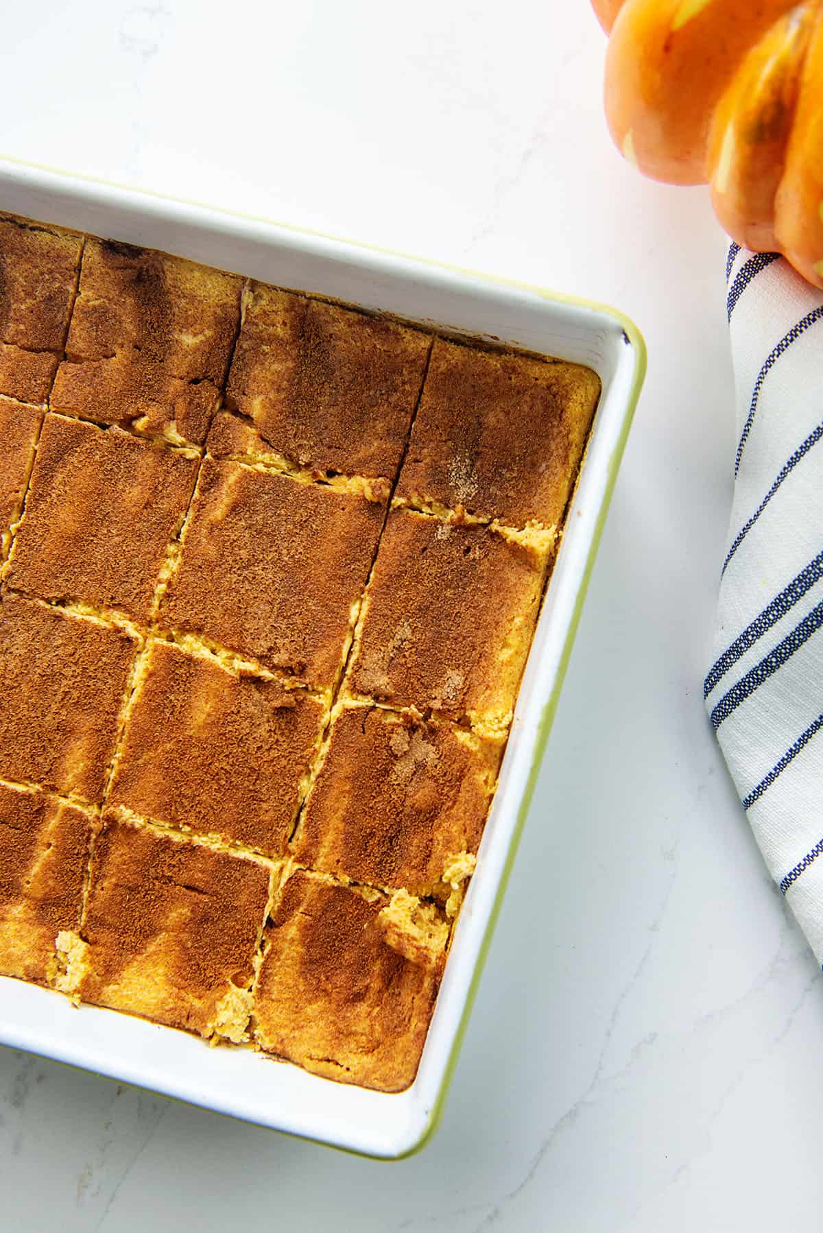 sliced cheesecake in white baking dish.