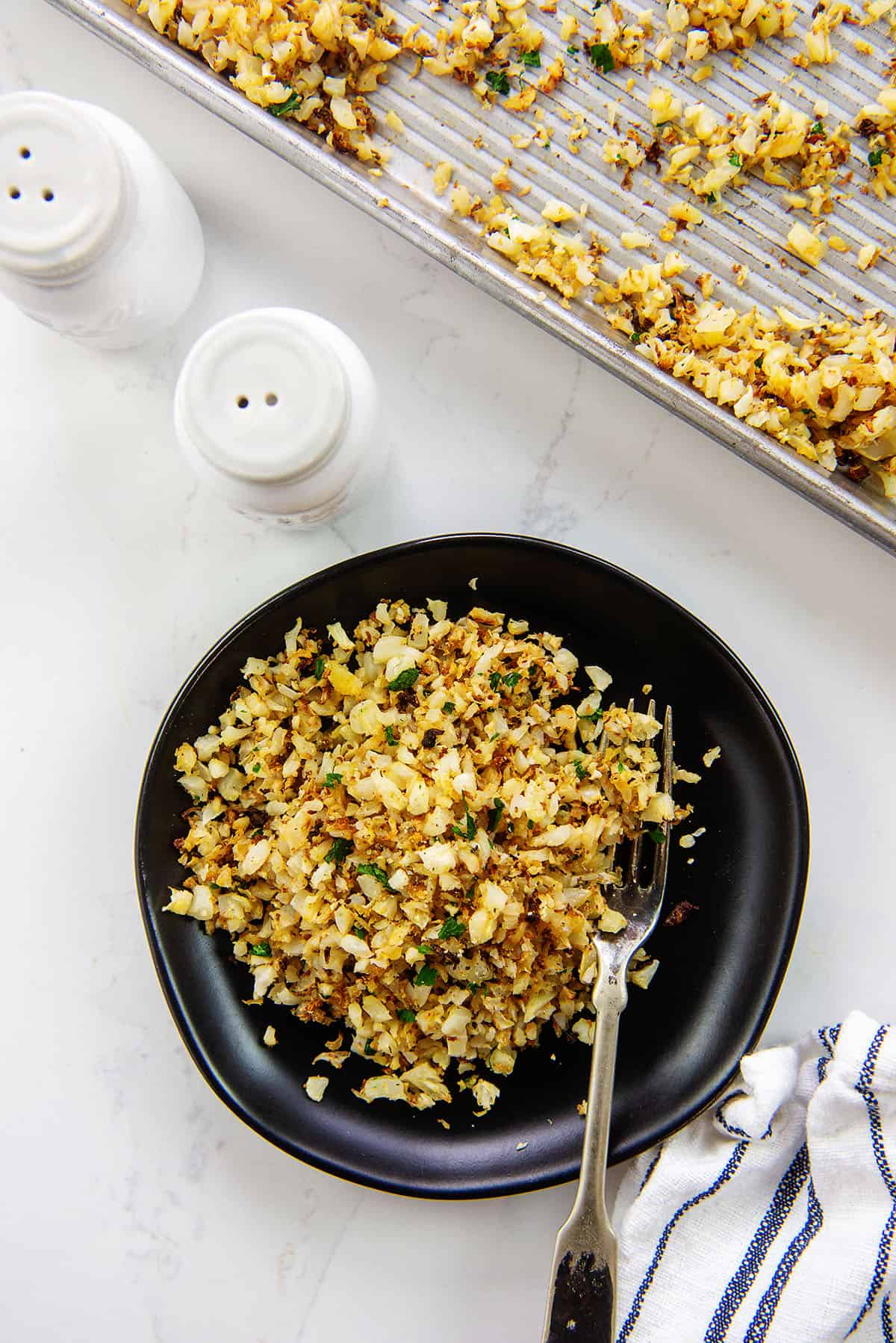 cauliflower rice on black plate.