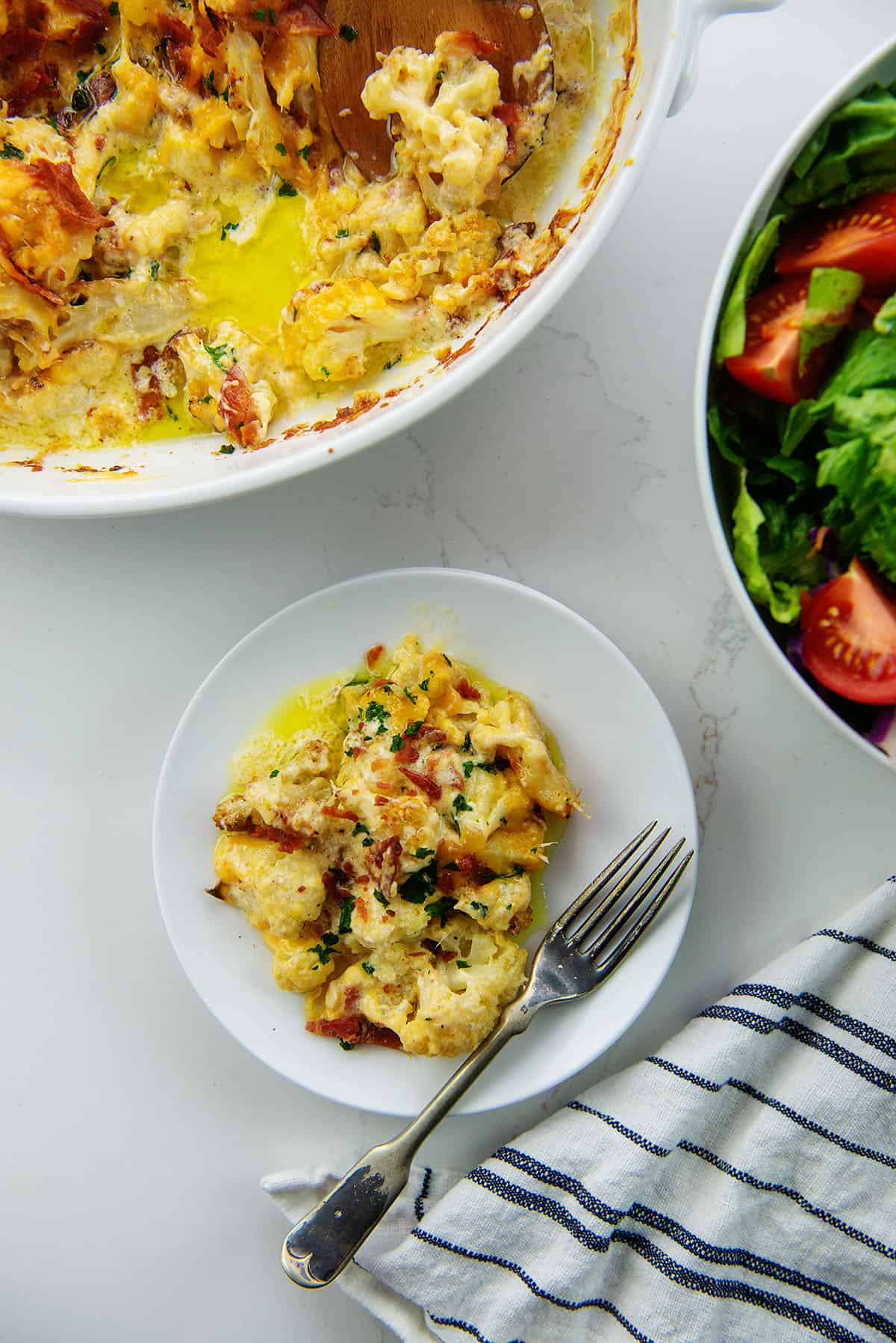 cheesy baked cauliflower on white plate.