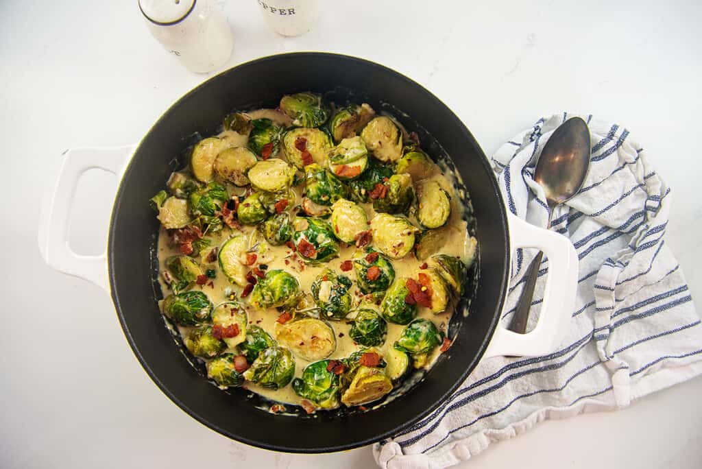 creamy Brussels sprouts in white skillet.