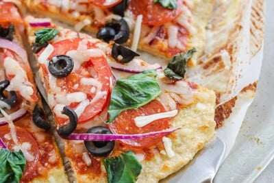 protein pizza crust topped with pepperoni and olives.