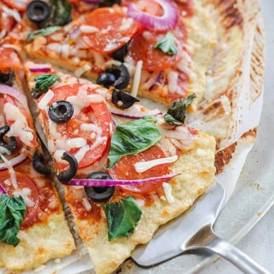 protein pizza crust topped with pepperoni and olives.