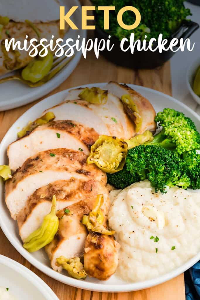 Sliced Mississippi chicken on white plate with cauliflower and broccoli.