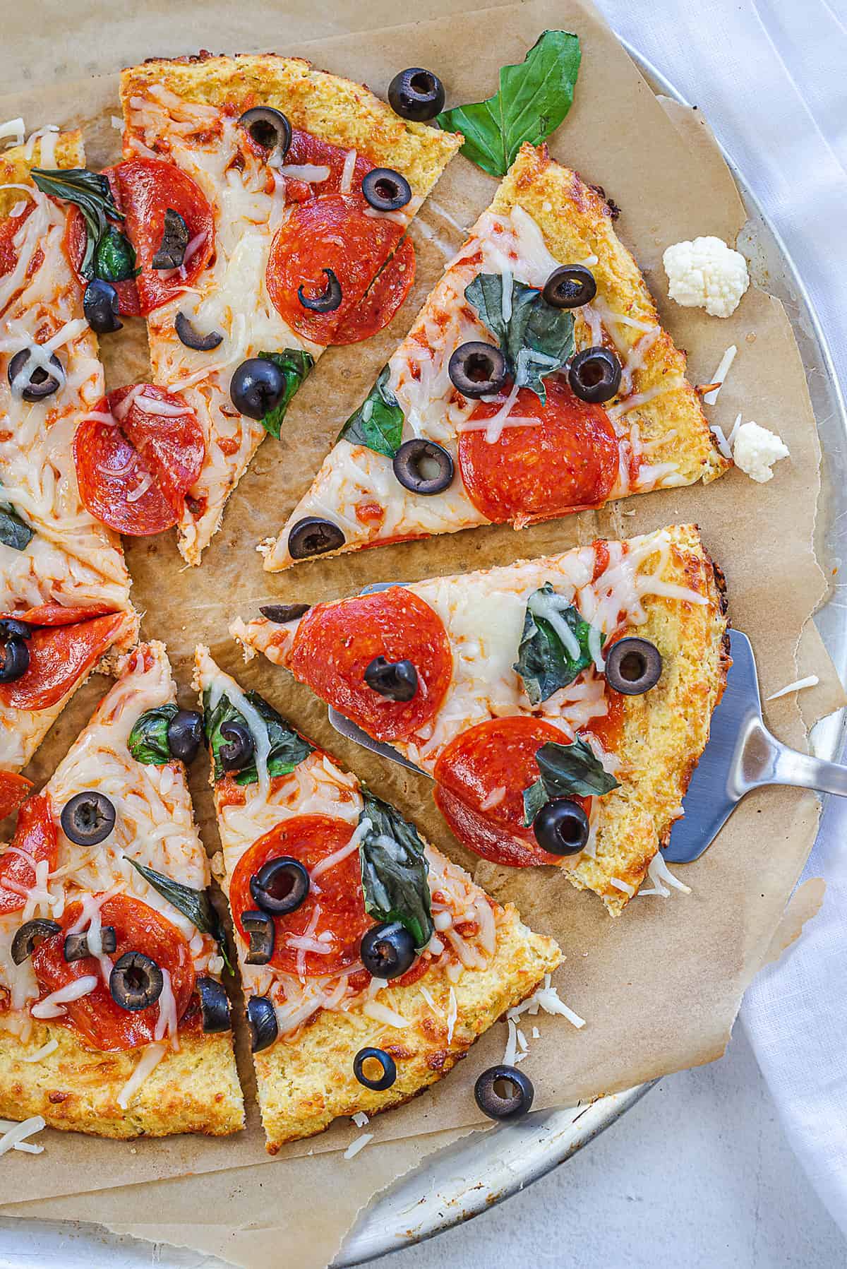 keto cauliflower crust pizza on pizza pan.