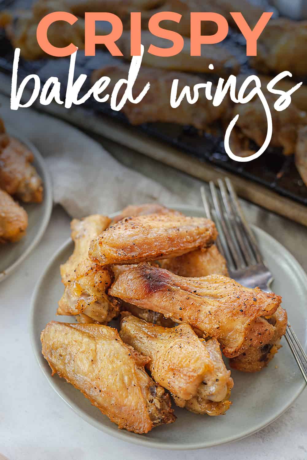 crispy baked chicken wings on plate with text for Pinterest.