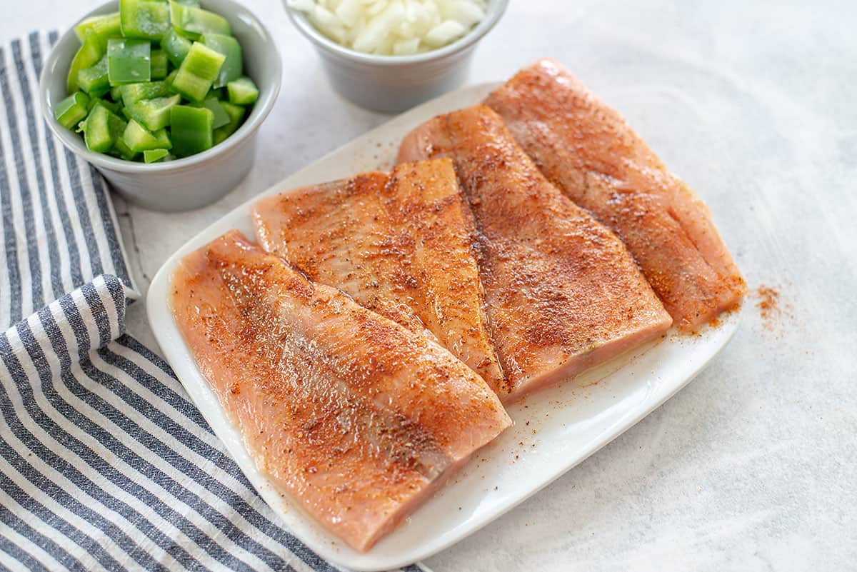 seasoned salmon filets on white plate.