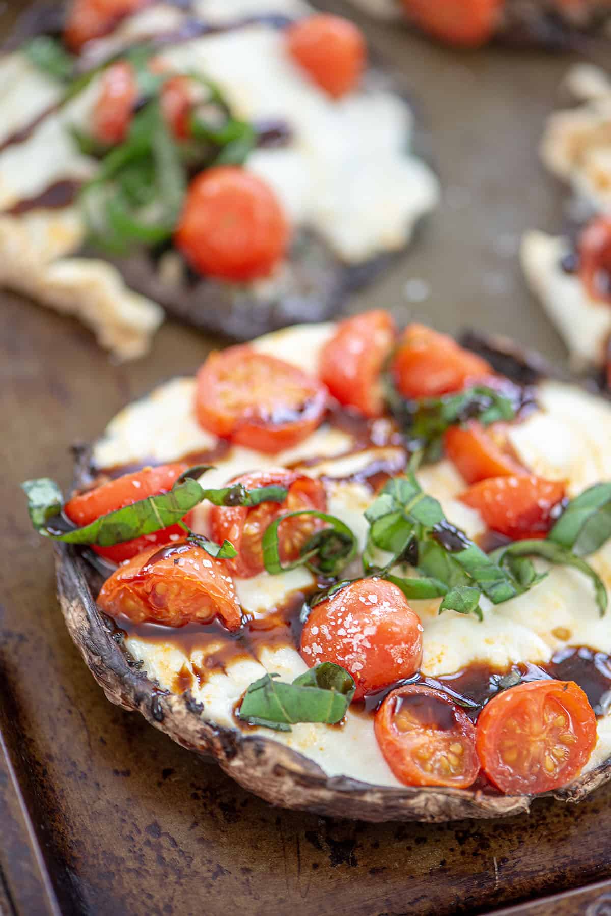 caprese stuffed mushroom caps on baking pan.