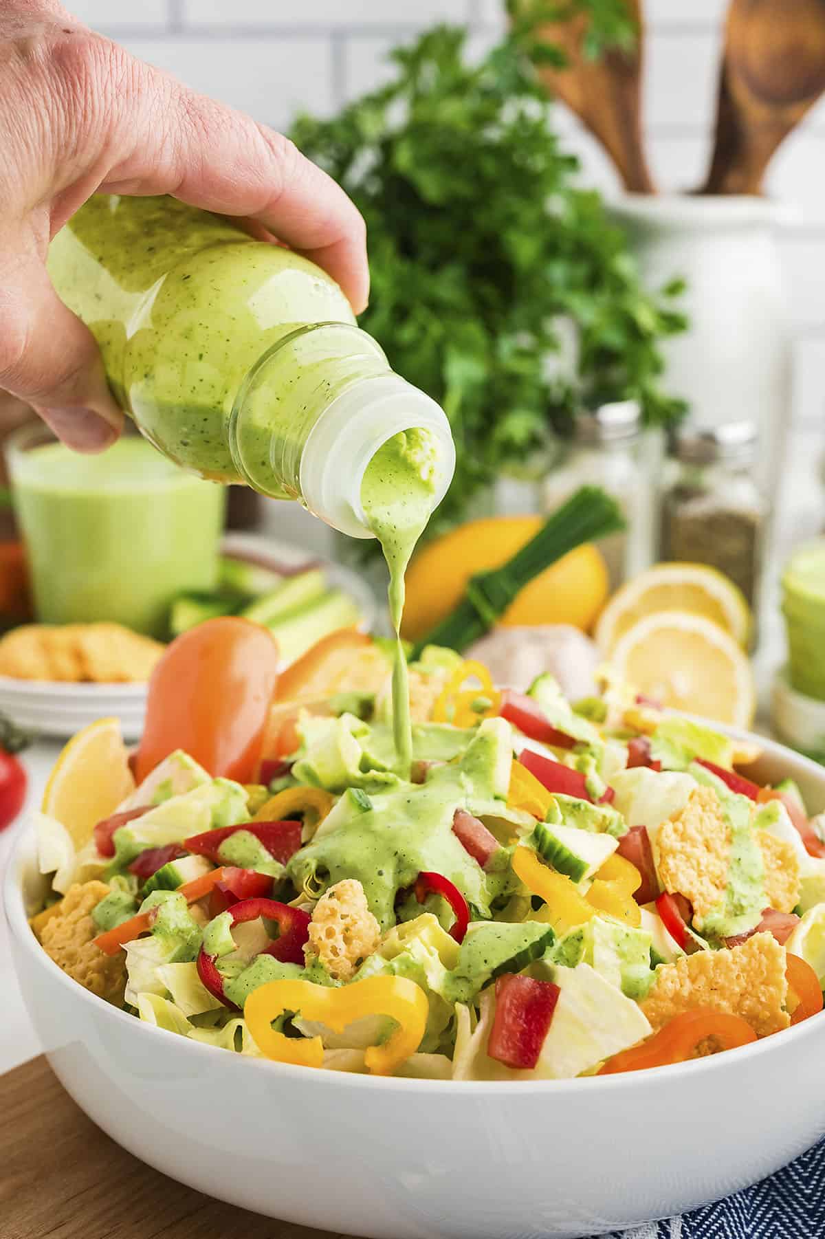 Green goddess dressing being drizzled over salad.