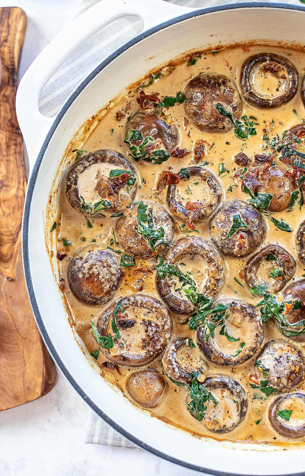 Creamy Tuscan Mushrooms in white pot.