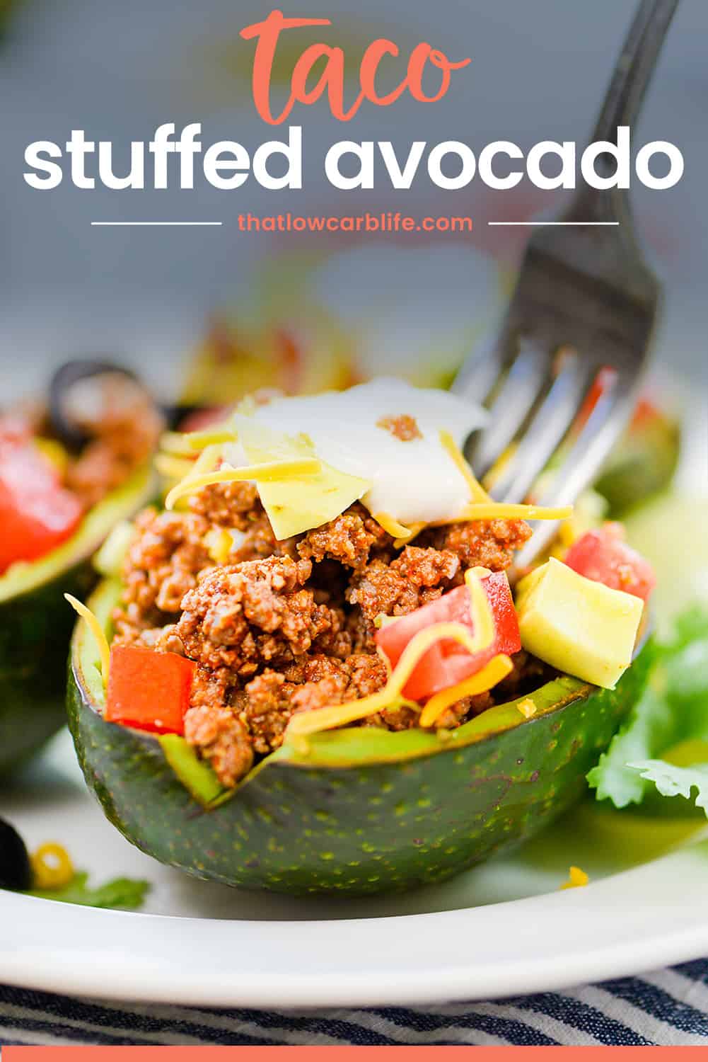 Taco stuffed Avocado on plate with fork.