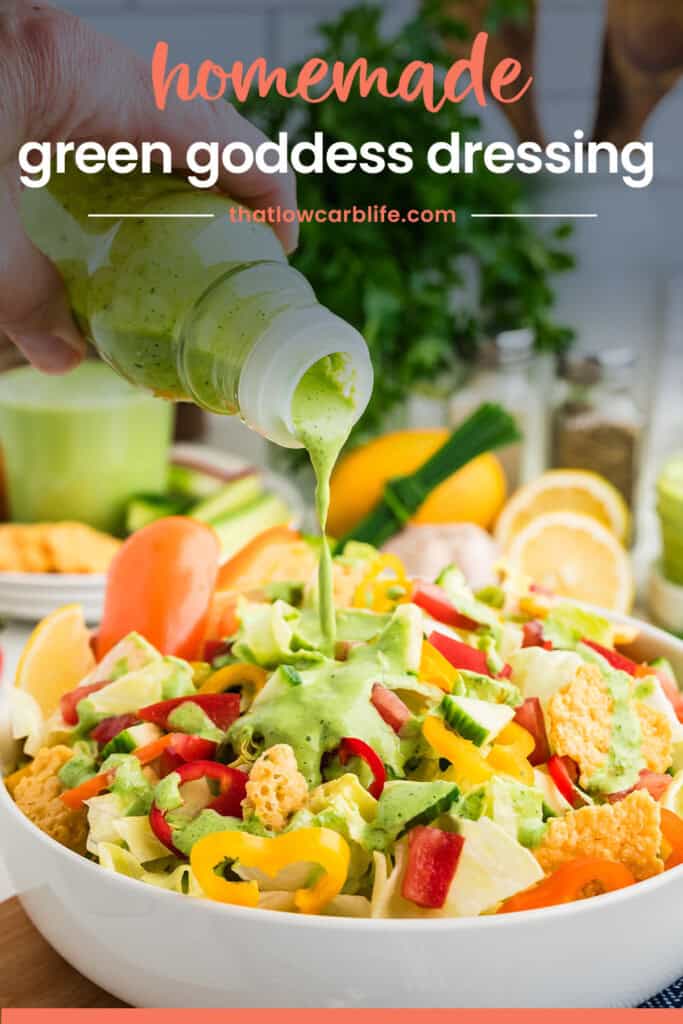 Green goddess salad dressing being poured over salad.