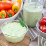 green goddess dressing in bowl with vegetables.