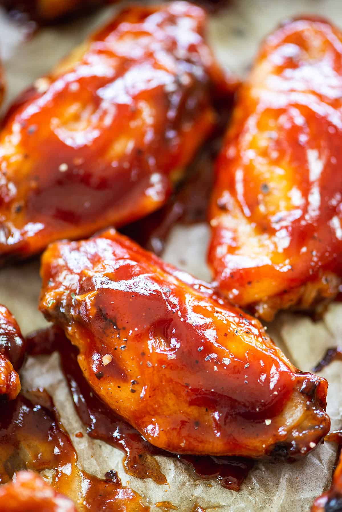 Saucy baked BBQ wings on pan.
