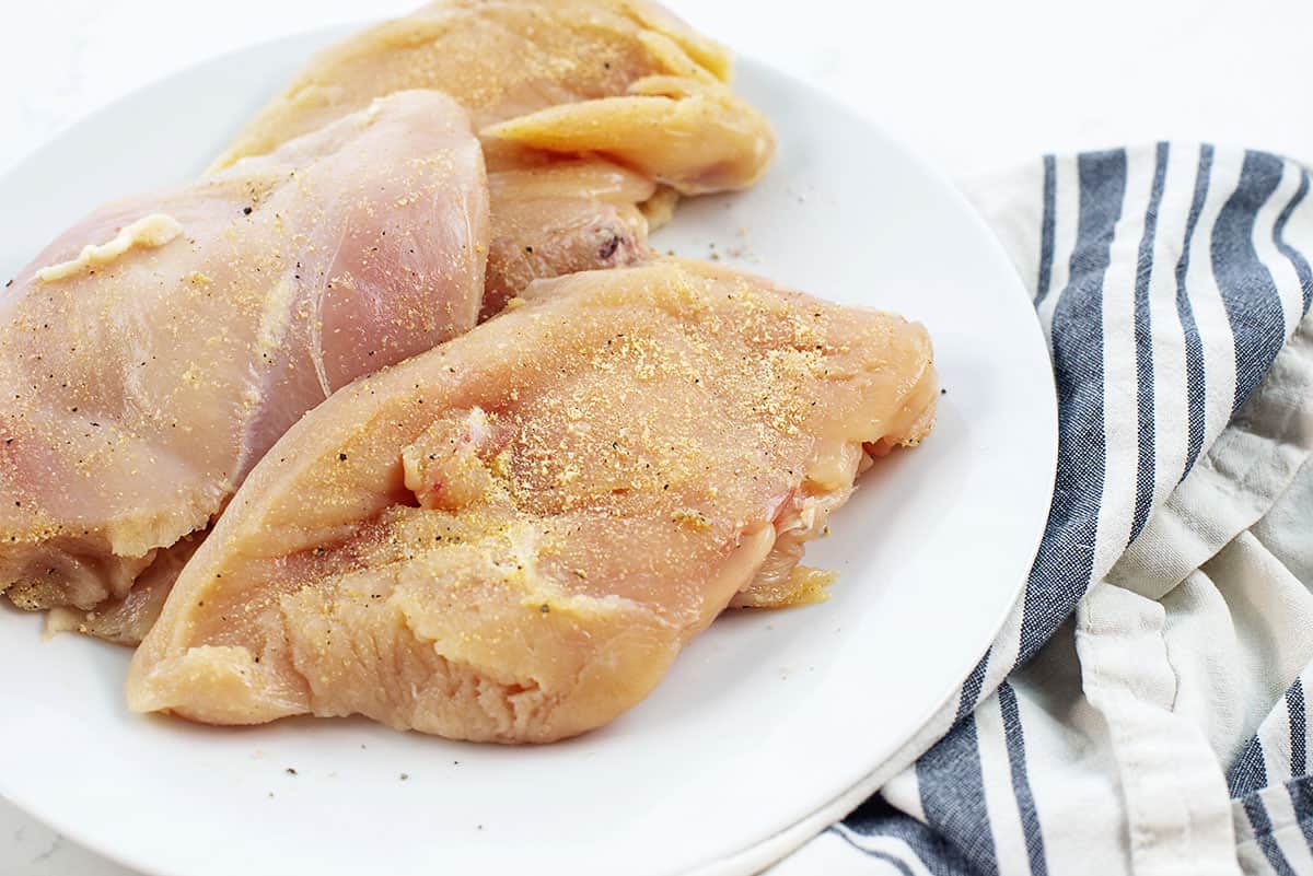 seasoned chicken breasts on white plate.