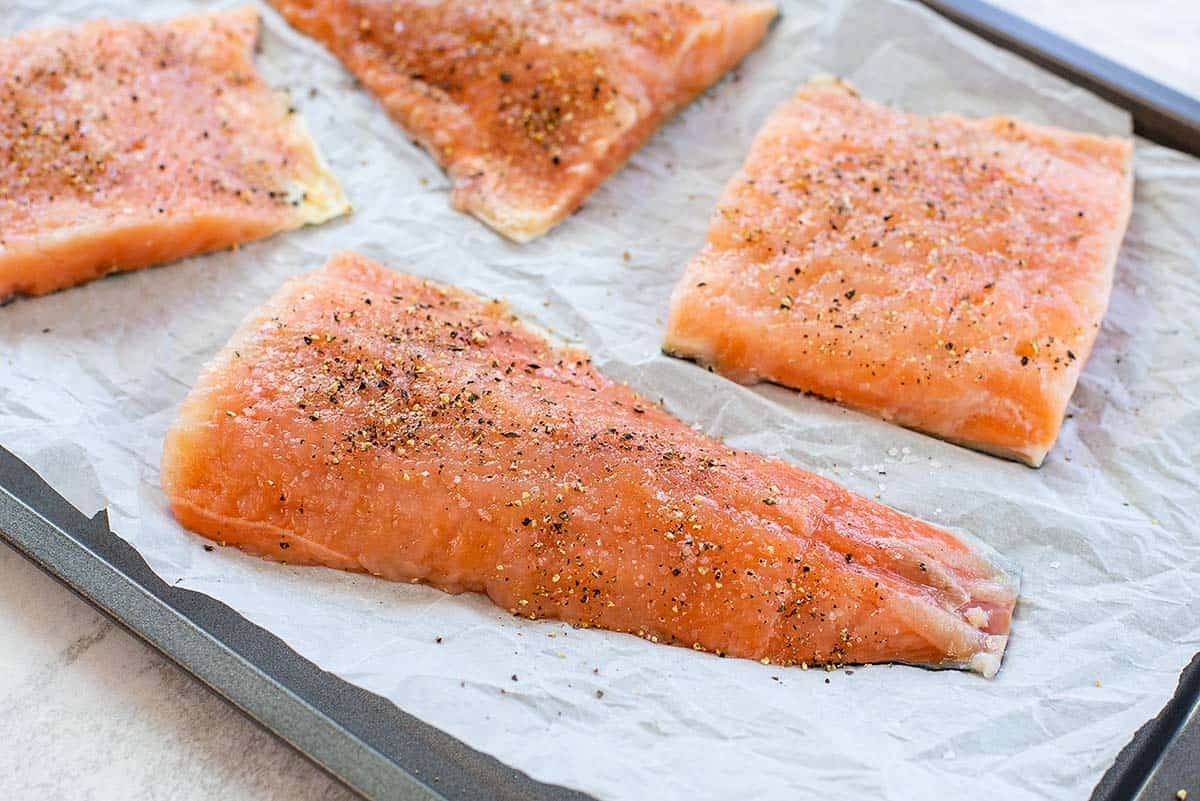 seasoned salmon filets on baking sheet.