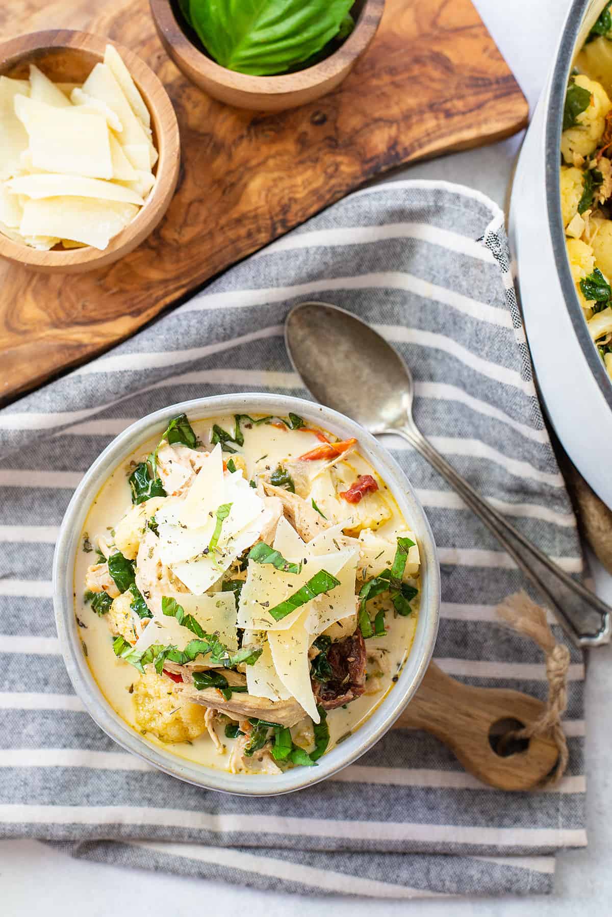 Tuscan chicken soup in white bowl on napkin.