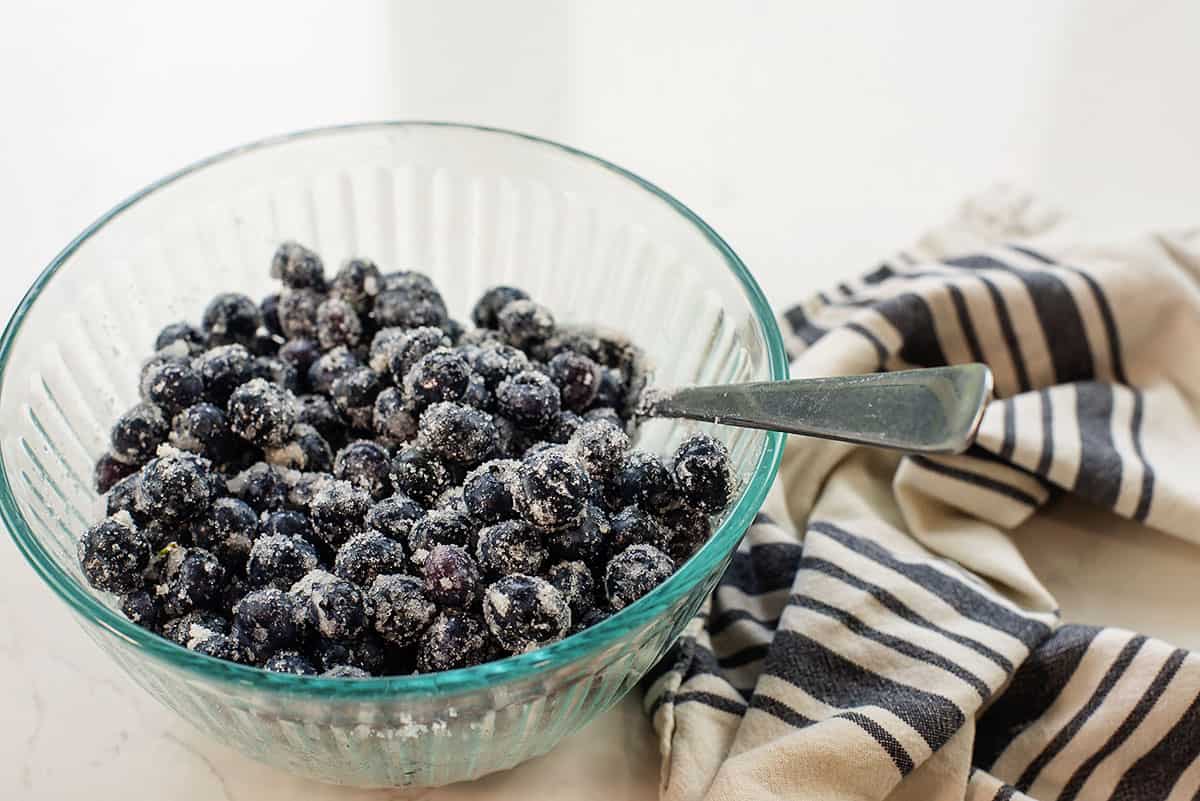 blueberries sprinkled with sweetener in glass bowl.