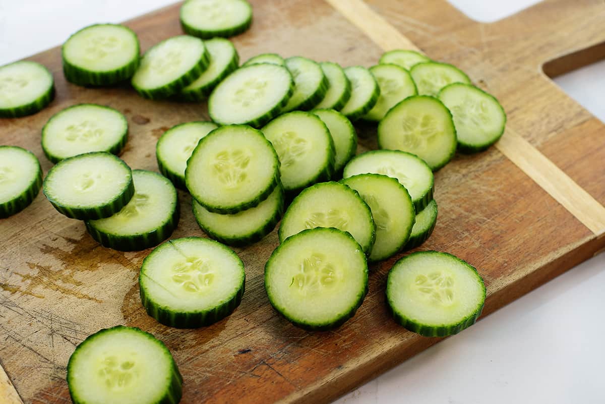 sliced cucumber on wooden board.