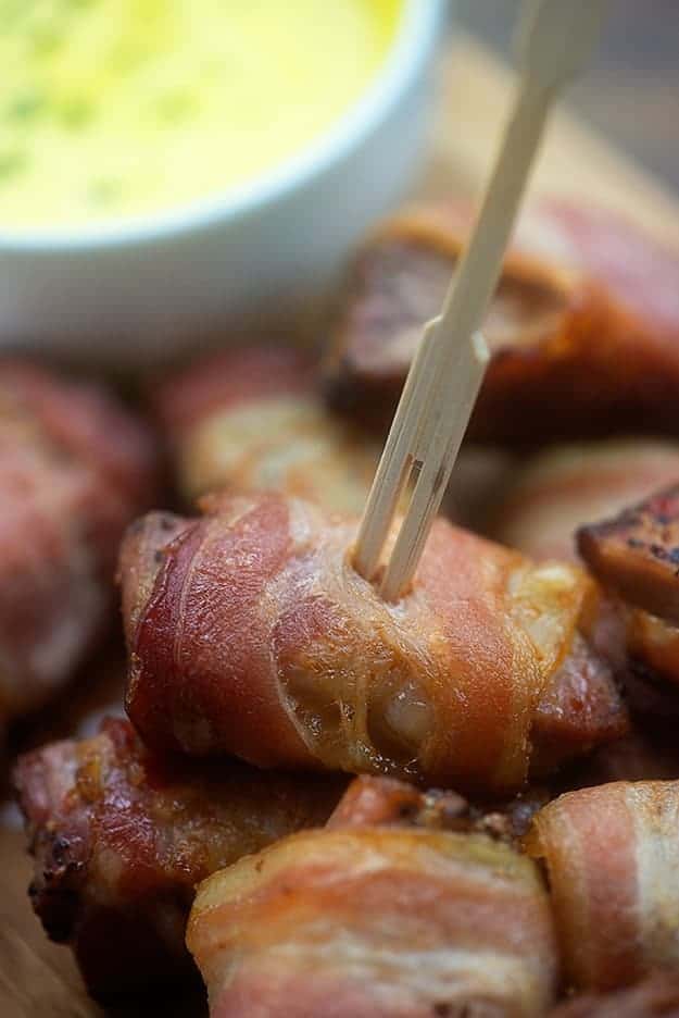 A close up view of bacon wrapped pork bites with a toothpick in one of them.