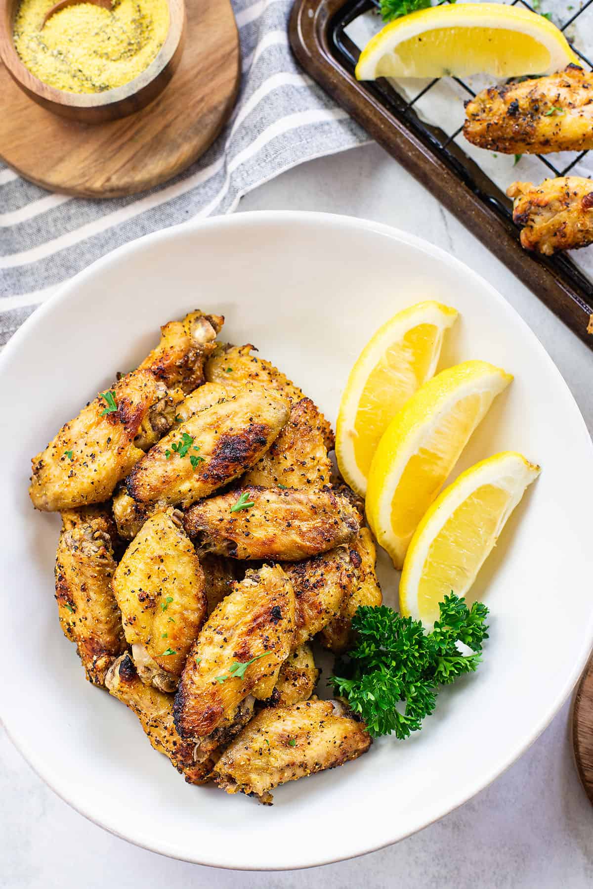 overhead view of lemon pepper wings in white bowl.