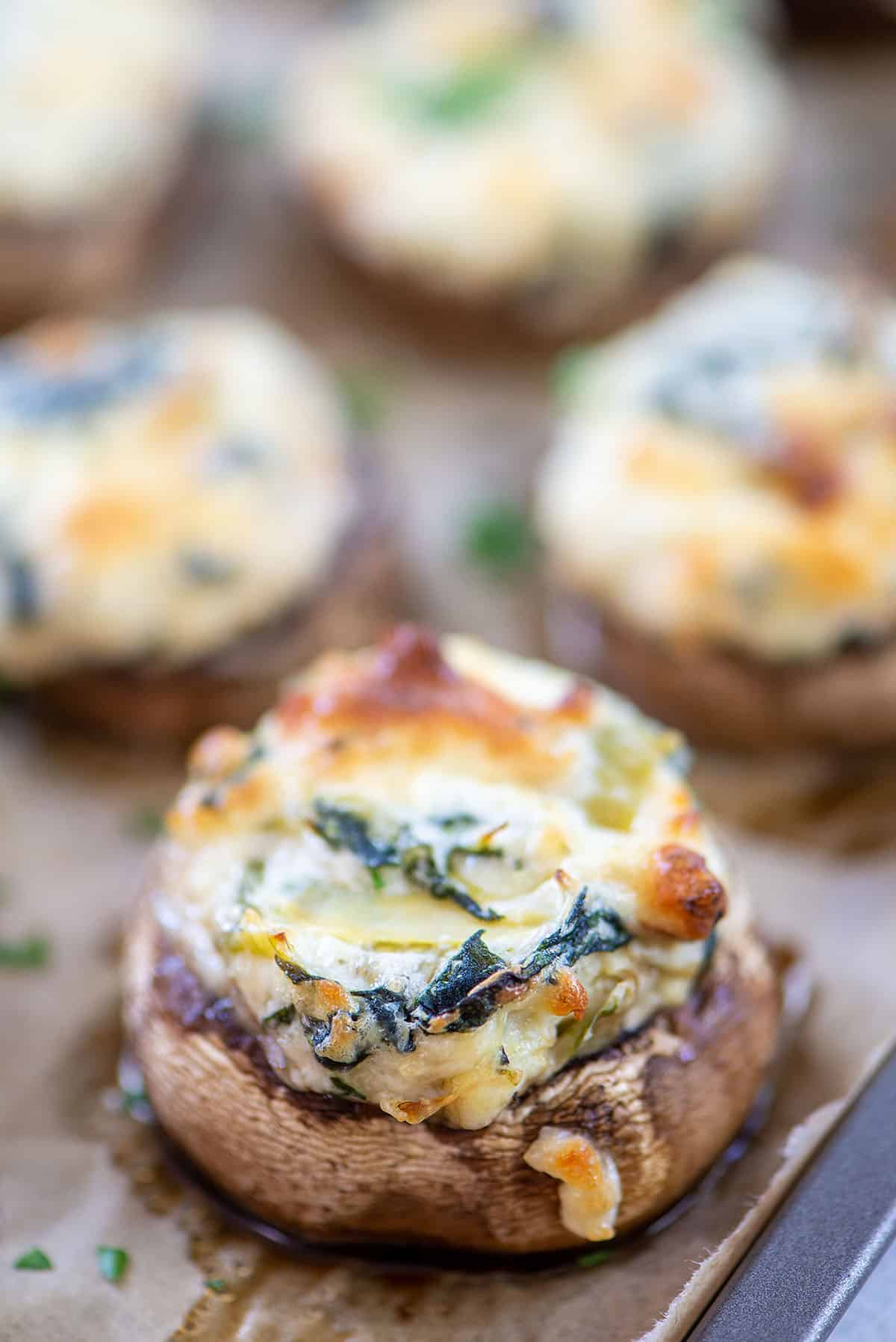 cheesy spinach stuffed mushrooms on baking sheet.