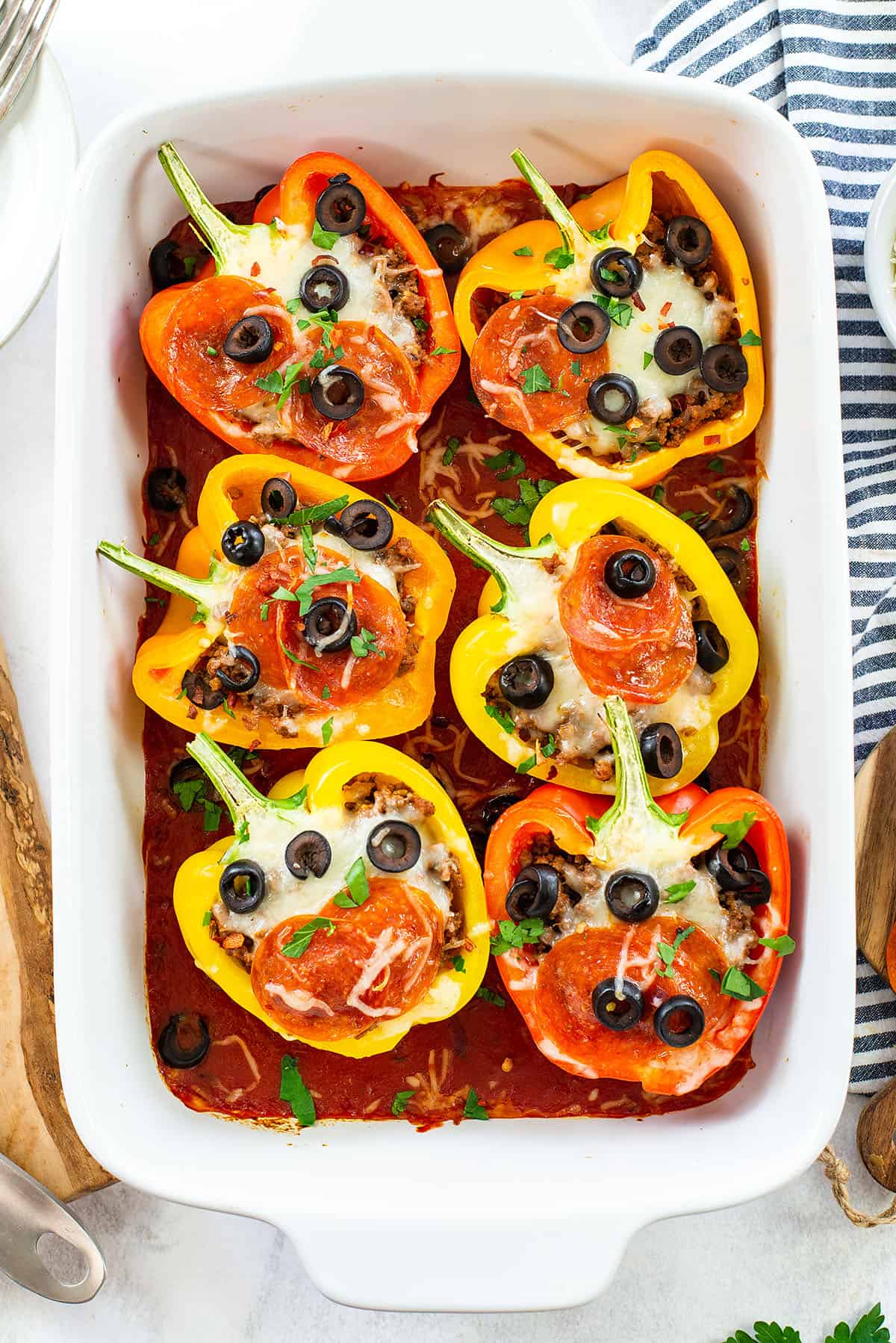 baked pizza stuffed peppers in white dish.
