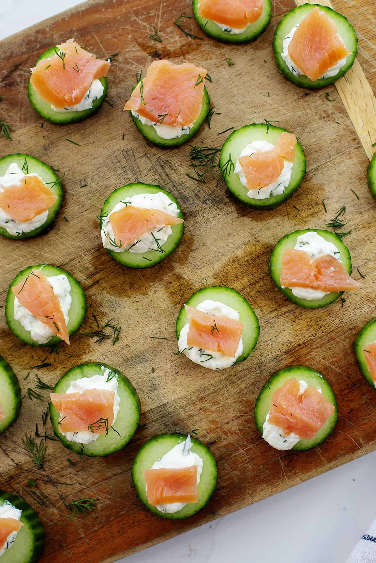 cucumber salmon bites on wooden board.