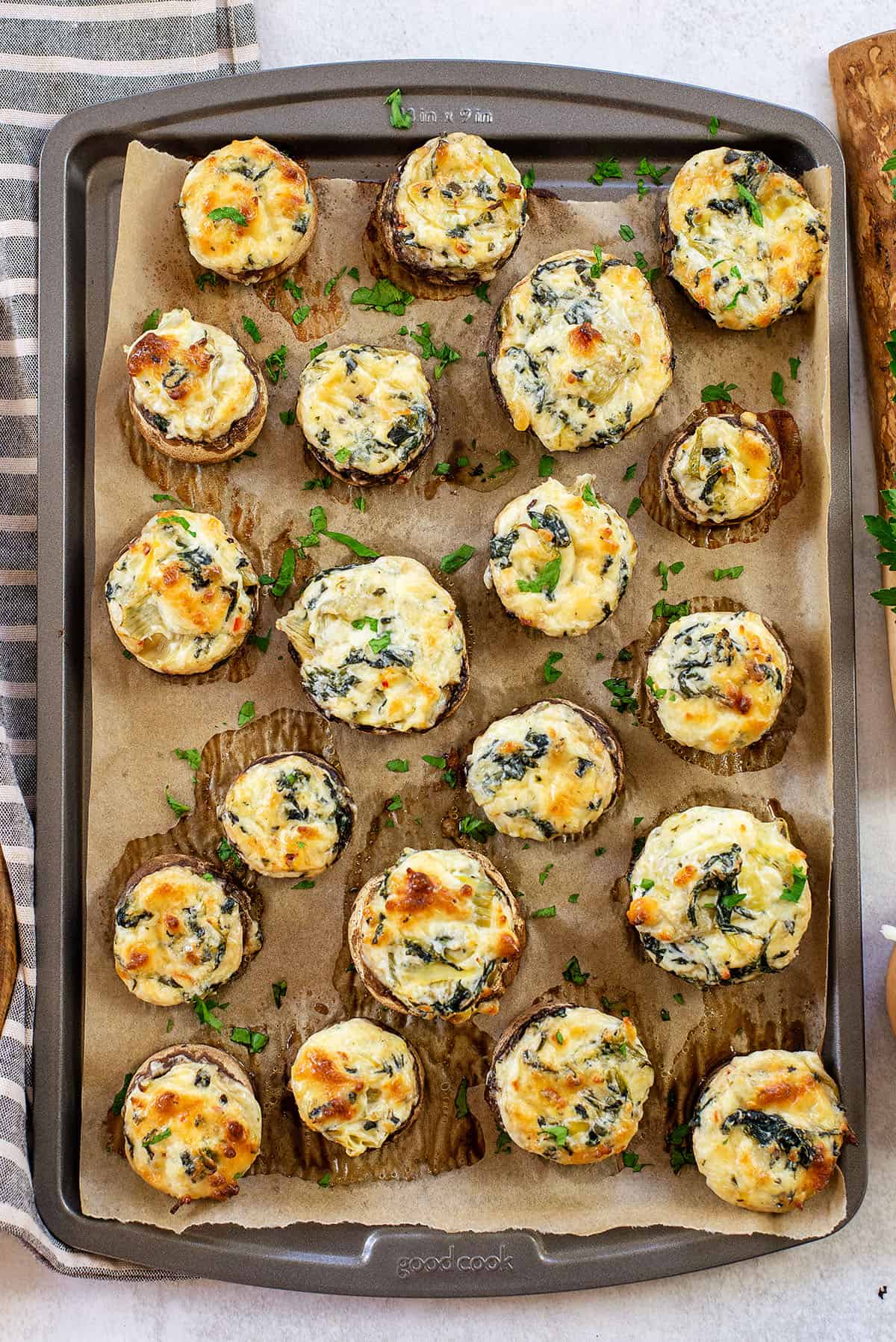 baked cheesy spinach artichoke stuffed peppers on baking sheet.