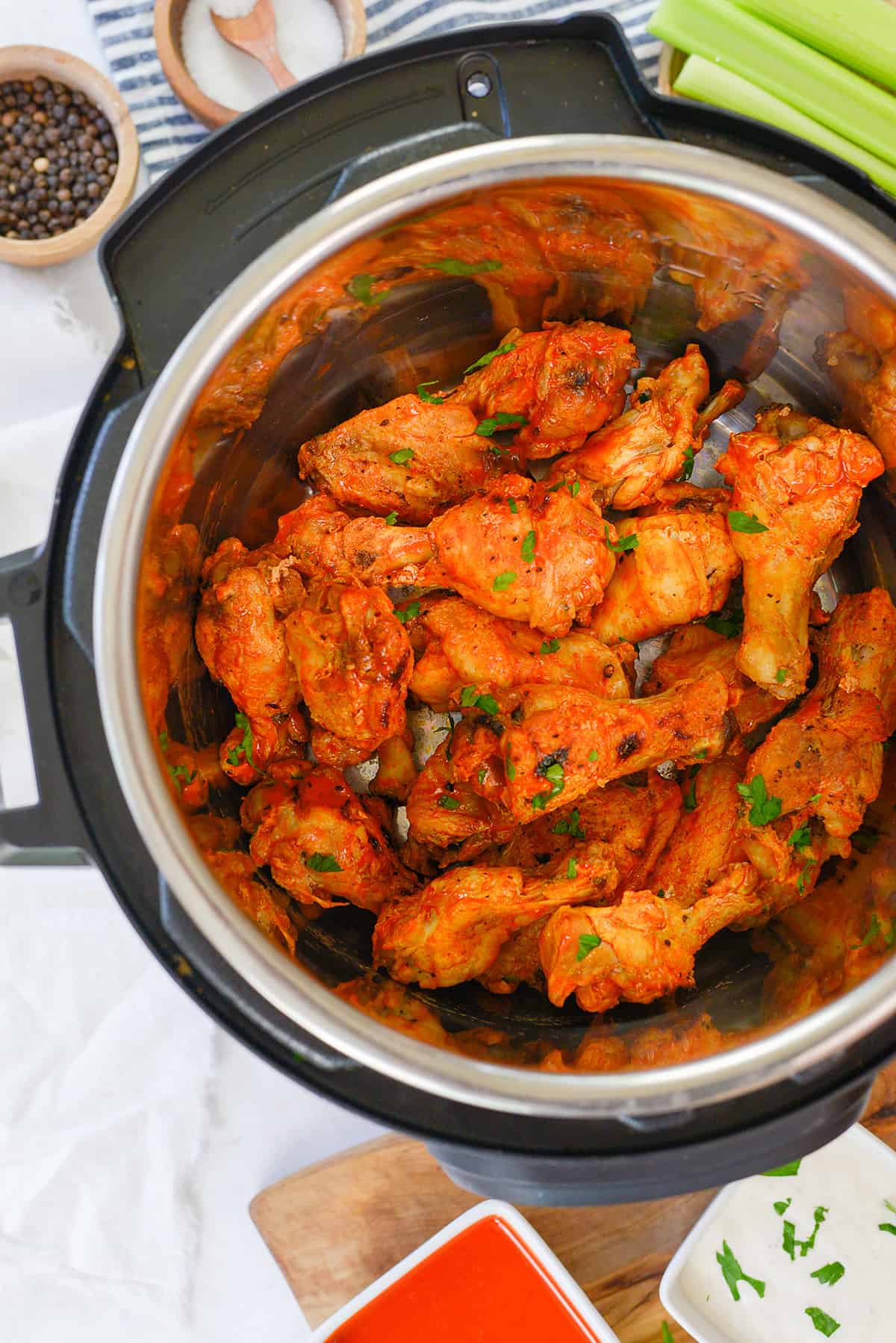 Chicken wings in Instant Pot tossed in buffalo sauce.