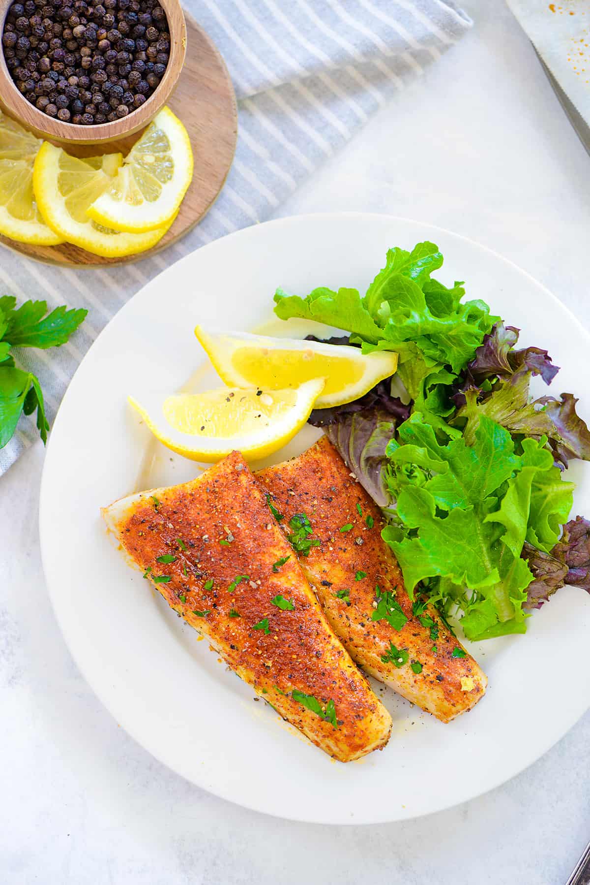 lemon pepper mahi mahi on white plate.