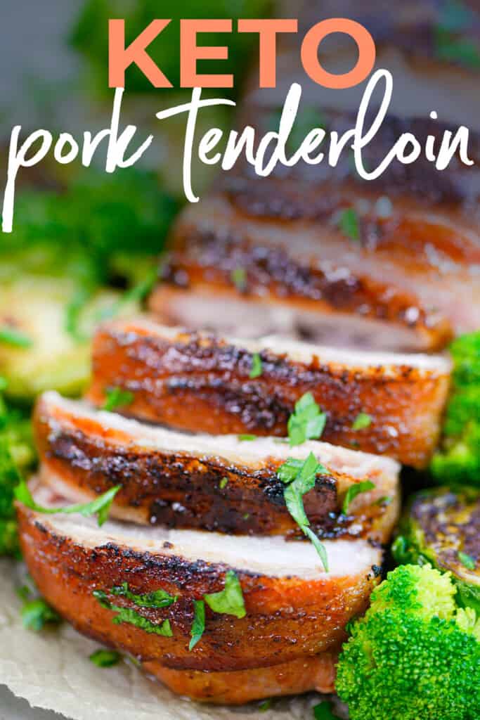 Keto pork tenderloin on sheet pan surrounded by veggies.