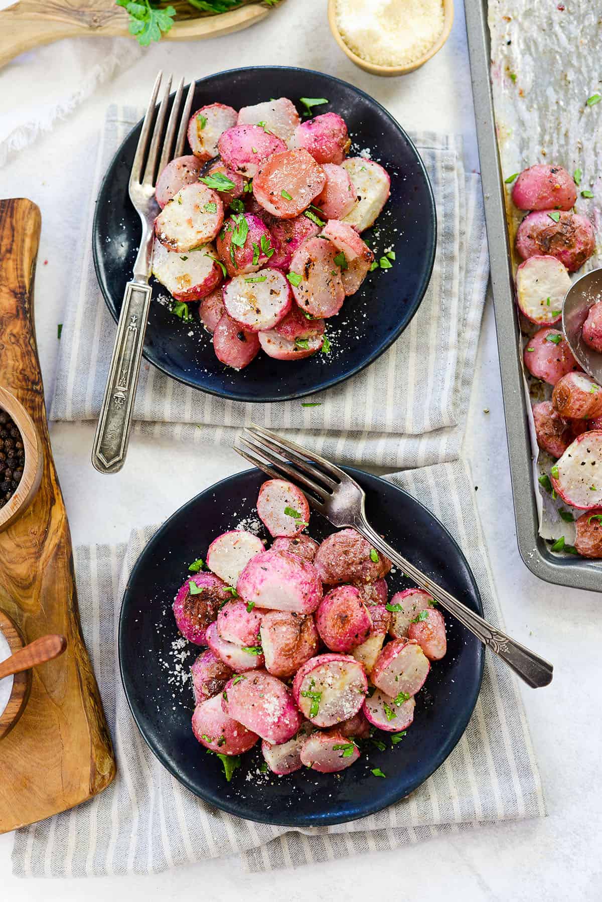 roasted radishes on black plates.