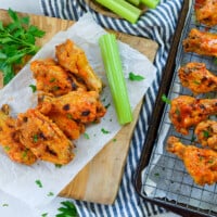 Buffalo chicken wings on sheet pan and parchment paper.