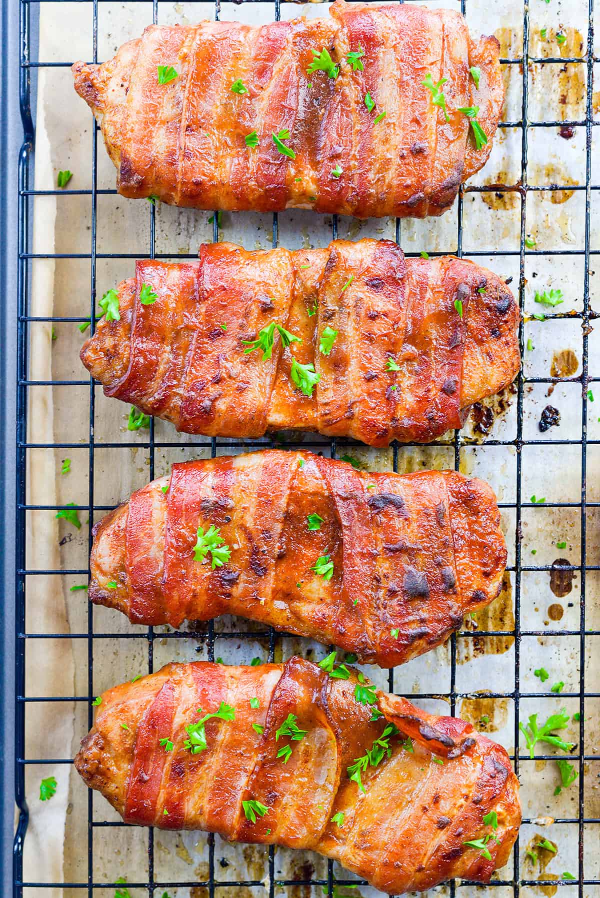 Bacon wrapped pork chops on rack.