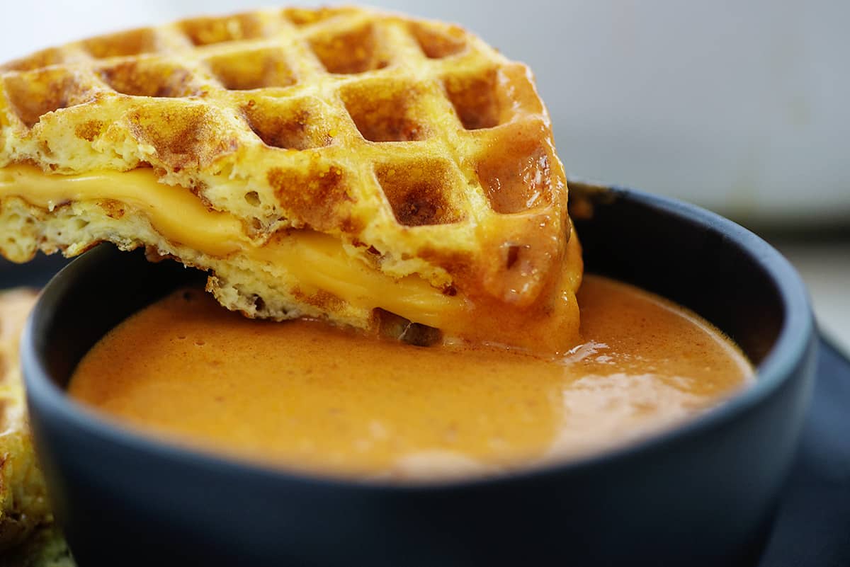 Keto tomato soup with grilled cheese chaffle on bowl.