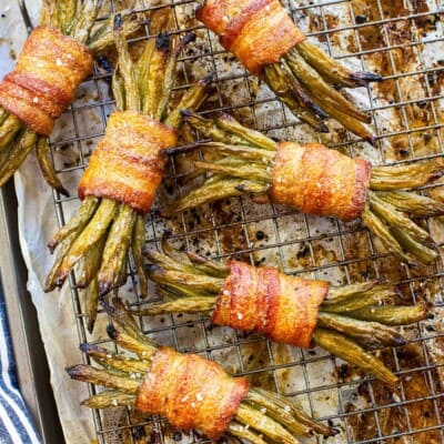 Bacon wrapped green beans on rack over pan.