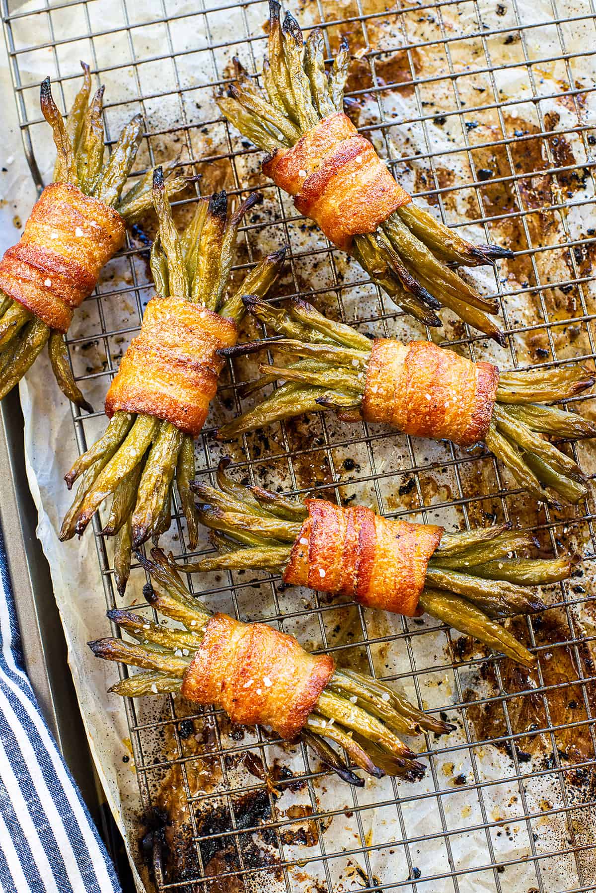 Bacon wrapped green beans on rack over pan.