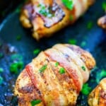 Chicken wrapped in bacon in cast iron skillet.